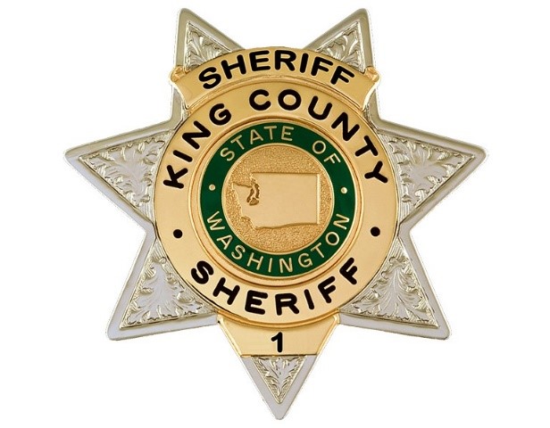 A gold and silver sheriff's badge with a star shape, featuring 